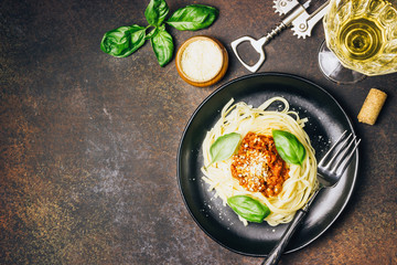 tagliatelle pasta with bolognese sauce and parmesan cheese in black plate