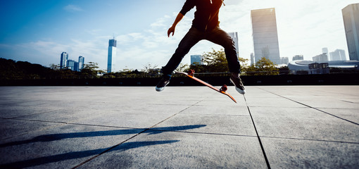 female skateboarder doing a heel flip on skateboard in city