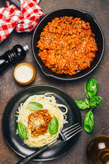 tagliatelle pasta with bolognese sauce and parmesan cheese in black plate