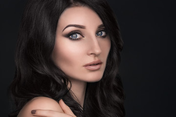 Naklejka premium Portrait of a sexy brunette with an elegant hairstyle and evening makeup