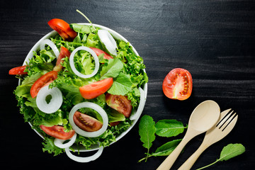 Organic vegetable salad, fresh, clean, healthy food With fresh tomatoes, onions, lettuce on the plate, food menu Top view, black background - image