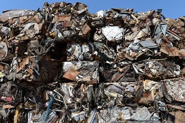 Large stack of compacted scrap metal blocks for scrap metal recycling in the USA.