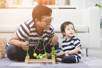 VIew of a Father and his little daughter playing together at home .