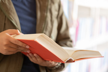 In the library - Teenage girl student with books reading in a high school library.