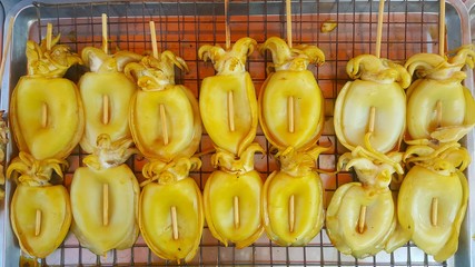 Grilled squid that is commonly sold in tourist attractions of Thailand. Grilled squid