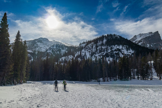 Skiers crossing frozen Nymph Lake, Rocky Mountain National Park, Colorado