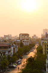 Daily traffic and city life on the busy streets of Mandalay during sunset. Mandalay is the...