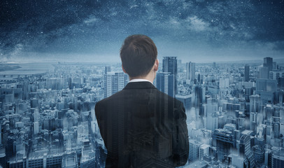 Businessman looking to futuristic blue city with starry sky. Smart business, business vision and...