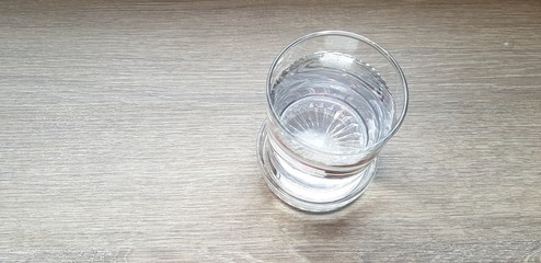 Top view or Flat lay Glass of cold water putting on light brown or gray wooden table for background with copy space - Refreshment, Drink, Object, Clearly and Shinning concept   