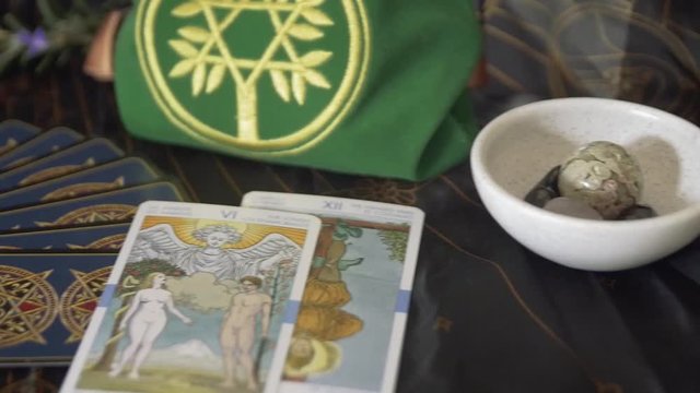 Slow pan across altar and crystals, placing tarot cards on table