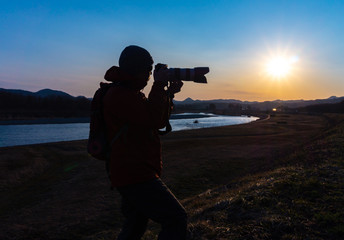 Obraz premium 美しい風景写真を撮影するカメラマンの男性