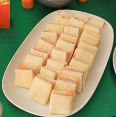 Homemade sandwich in white tray.