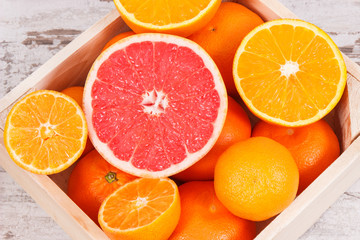 Fresh citrus fruits in wooden box. Slimming, diet and healthy nutrition concept