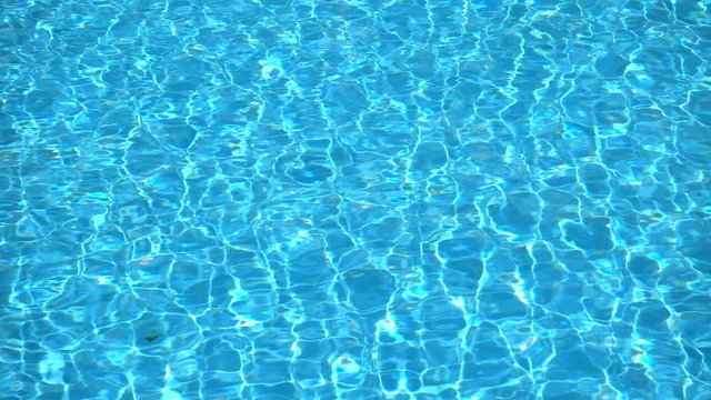 The crystal clear water of the pool creates a play of light with the reflection of the sun. 4K Resolution