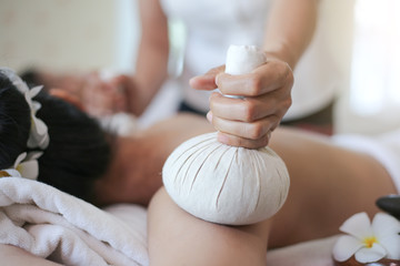 Obraz na płótnie Canvas Body care. Spa body massage treatment with hot herbal ball for deep relaxation
