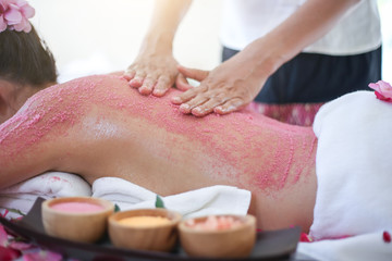 Obraz na płótnie Canvas Young woman receiving salt massage in spa salon