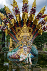 Fototapeta premium Statues of Buddhist mythology in a fountain. Buddha with Naga. Thailand