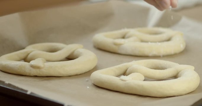 Slowmotion shot, salt being put on frozen pretzels.