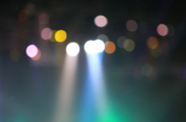 Blurred Concert light with colored spotlights and smoke.