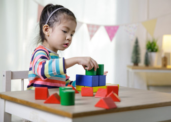 Kid's creativity, Child little asian girl playing colorful building blocks on the desk in the class room at home, Educational concept for school