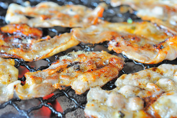 Close up shot pork grilling and bacon on grill plate. Eating Korean BBQ.