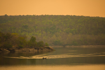 Small fishing boat is sailing in the reservoir in the valley
