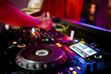 DJ remote on stage at the nightclub. background of dancing people.