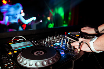 Fototapeta na wymiar DJ remote on stage at the nightclub. background of dancing people.