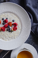 Menu at the cafe, Breakfast, Porridge with berries, Bulgur with coconut milk. Flatlay, Top view, Moody on black background, Darkstyle