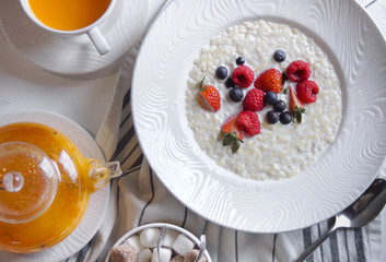 Menu at the cafe, Breakfast, Porridge with berries, Bulgur with coconut milk. Flatlay, Top view, Moody on black background, Darkstyle