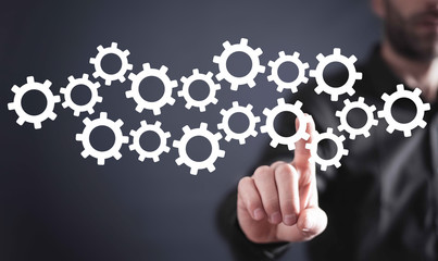 Businessman hand touching on gears.