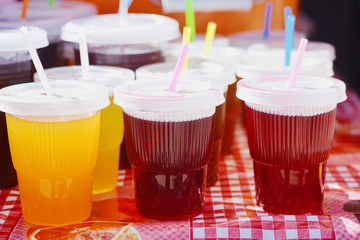 Red and yellow drinks in glasses with straw.