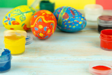 Close-up paints and Easter eggs on multicolor wooden background with Easter eggs Easter crufts