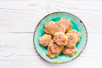 Ready-to-eat cottage cheese cookies on a plate on a wooden table. Top view