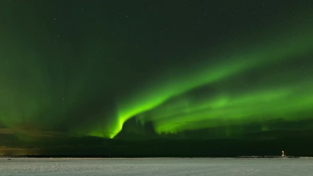 Timelapse of strong northern lights dancing above a snow-covered field with a lighthouse in the background.
Reykjavik, Iceland
