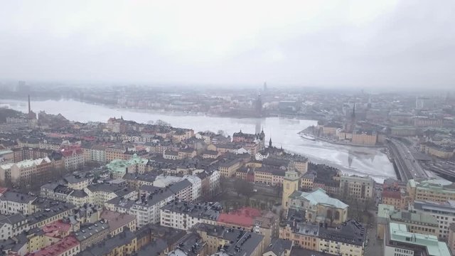 4K drone footage of a upward pan overlooking Stockholm during winter with its reflections in the water.