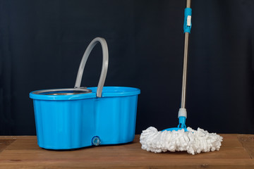 Floor cleaning with mob and bucket on background.