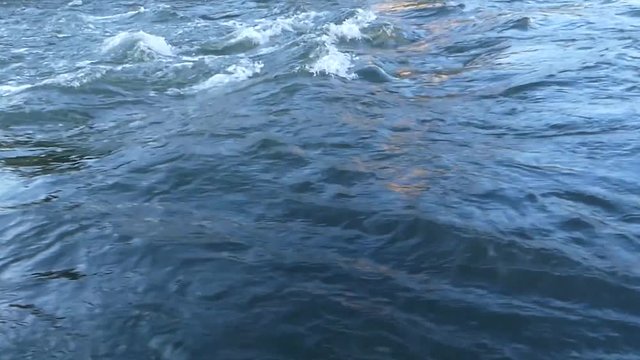 Footage of river water flows shot in low angle. Slow-mo.