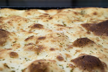 Typical Italian bread starter called Focaccia con rosmarion, close up