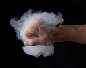 Fist punching white smoke against black background