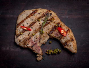 Grilled pork chops with spices and chilli isolated on wood,top view