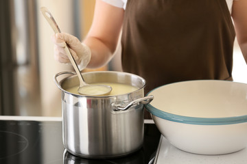 Obraz na płótnie Canvas Woman preparing tasty cheese in kitchen