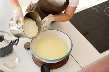 Woman preparing tasty cheese in kitchen