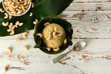 Bowl with traditional Indian food pongal on table