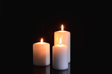 Burning candles on black background
