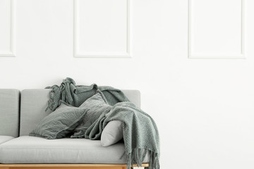 Soft sofa near white wall in room