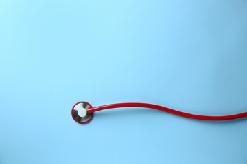 Medical stethoscope on color background
