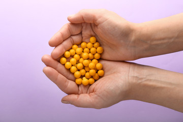 Female hands with pills on color background