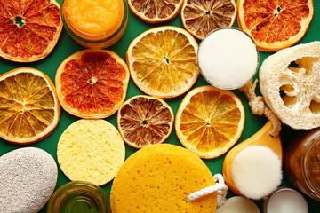 Sugar scrubs with citrus slices on color background