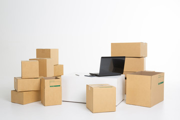 laptop computer at workplace of start up, small business owner, freelance, seller. cardboard parcel box of product for deliver to customer. Online selling, e-commerce, packing, shipping concept